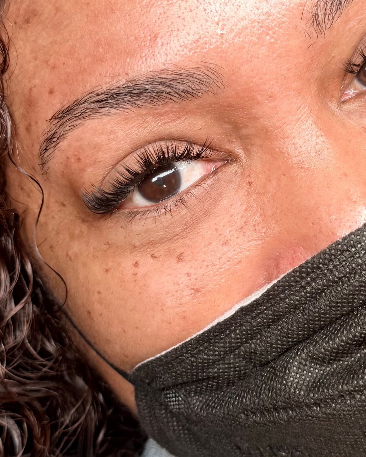 Close-up of a client's hybrid lash set with wispy texture